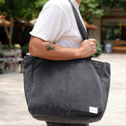 Person carrying a gray shoulder bag outdoors
